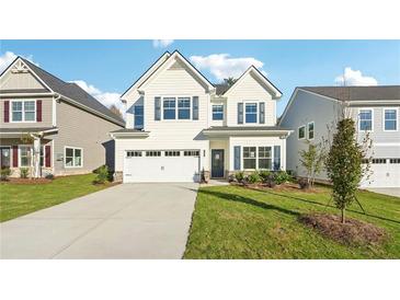 Charming two-story home features a well-manicured lawn, two-car garage, and classic architectural details at 11850 Rizvan Pl, Covington, GA 30014
