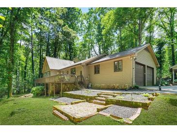 Charming home with a deck, two-car garage, and a well-maintained yard surrounded by lush greenery at 5837 Fox Run, Rex, GA 30273