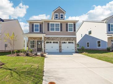 Charming two-story home featuring a brick facade, two-car garage, and well-manicured lawn at 11854 Rizvan Pl, Covington, GA 30014