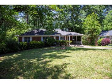 Charming brick home featuring a well-manicured front yard with mature trees at 1398 Christmas Ne Ln, Atlanta, GA 30329