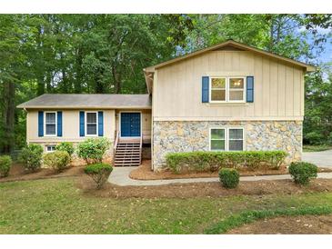 Charming two-story home with stone accents, blue shutters, landscaped yard, and inviting front entrance at 1415 Hialeah Ct, Marietta, GA 30062