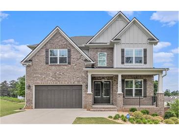 Beautiful two-story brick home with a covered porch, two-car garage and manicured landscaping at 3139 Hilltop Drive, Marietta, GA 30066