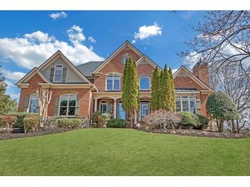 Stately brick home featuring a lush lawn, manicured landscaping, and architectural details at 2740 Heritage Bend Sw Ct, Grayson, GA 30017