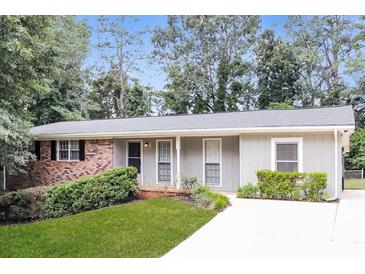 Charming single-story home with a well-maintained lawn and classic brick accents at 4820 Oak Grove Dr, Cumming, GA 30040