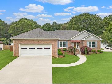 Charming brick home with a well-manicured lawn, two-car garage, and inviting walkway at 1419 Gates Mill Walk, Lawrenceville, GA 30045