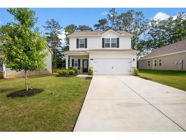 Charming two-story home with a well-manicured lawn and a concrete driveway leading to an attached two-car garage at 217 Limestone Cir, Conyers, GA 30013