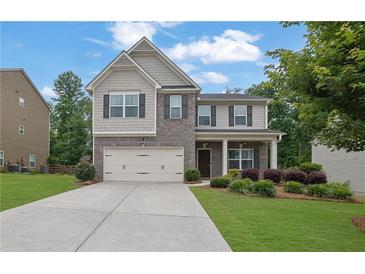 Charming two-story home featuring a brick facade, well-manicured lawn, and attached two-car garage at 6240 Vista Crossing Way, Cumming, GA 30028