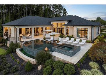 A beautiful backyard featuring a pool, hot tub, fire pit, and lounge area, perfect for outdoor entertaining at 3085 Lake Park Dr, Jonesboro, GA 30236