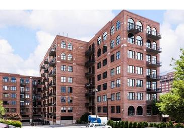 Brick apartment building with windows, balconies, and arched windows on a partly cloudy day at 3235 Roswell Ne Rd # 514, Atlanta, GA 30305