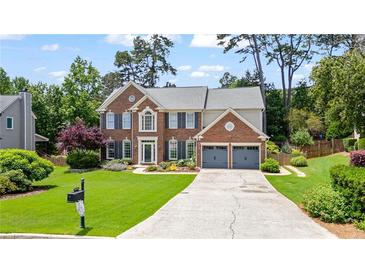 Charming two-story brick home with a manicured lawn and a two-car garage at 8045 Depford Way, Cumming, GA 30041