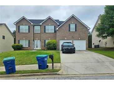 Two-story brick home with a well-maintained lawn and two-car garage at 4925 Locherby Dr, Fairburn, GA 30213