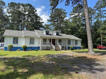 Charming single story home with a white facade, blue trim, dormer windows, and a welcoming front porch at 1833 Stephenson Rd, Lithonia, GA 30058