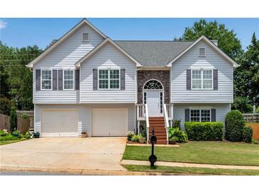 Charming two-story home with a two-car garage, stone accents, and a well-maintained lawn at 607 Lexington Way, Woodstock, GA 30189