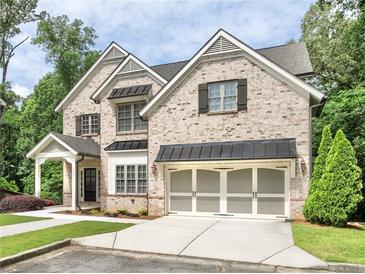 Charming two-story brick home featuring manicured lawn, black shutters, and a convenient two-car garage at 1300 Winfair Ne Ln, Brookhaven, GA 30329
