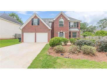 Charming two-story brick home with a well-manicured lawn and attached two-car garage at 330 Kentwood Springs Dr, Hampton, GA 30228