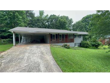 Charming one-story home with a carport, front porch and classic brick exterior at 5924 Central Church Rd, Douglasville, GA 30135