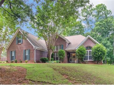 Charming brick home with well-manicured lawn, mature trees, and inviting front entrance at 1585 Lake Dow Rd, Mcdonough, GA 30252