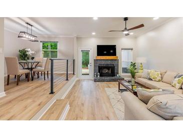 Bright living space with hardwood floors, fireplace, and an open floor plan to a dining area at 2012 Variations Ne Dr, Atlanta, GA 30329