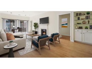 Bright living room features fireplace, comfortable seating, and a view to the outdoor area at 2921 Lenox Rd # 308, Atlanta, GA 30324