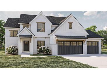 Charming two-story home featuring a white brick facade, black trim windows, and a two-car garage with carriage doors at 3629 Centerville Rosebud Rd, Snellville, GA 30039