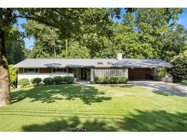 Charming brick home with a manicured lawn and a metal roof, surrounded by mature trees at 4020 N Cooper Lake Se Rd, Smyrna, GA 30082