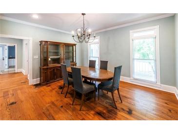 Traditional dining room featuring hardwood floors, a chandelier, a dark wood hutch, and two windows at 5780 Punkintown Rd, Douglasville, GA 30135