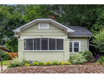 Charming single-Gathering home featuring a covered front porch, painted brick foundation, and lush landscaping at 1424 Van Epps Se Ave, Atlanta, GA 30316