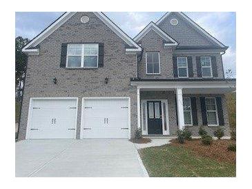 Two-story home with gray brick, black shutters, a two-car garage, and a covered front entrance at 1678 Lacebark Elm Way Way, Lawrenceville, GA 30045