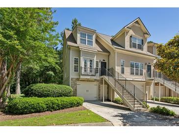 Charming townhome exterior with manicured landscaping, stairs, and one-car garage at 3150 Stonewyck Pl, Decatur, GA 30033