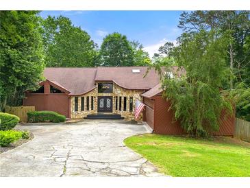 Charming single-story home with stone accents, mature trees, and a spacious driveway at 4710 Misty Lake Ne Ct, Kennesaw, GA 30144