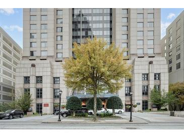Elegant exterior view of a luxury building with well-manicured landscaping, a large tree, and street access at 75 14Th St Ne # 4140, Atlanta, GA 30309