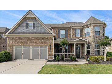 Inviting two-story home with manicured lawn, stone accents, and attached two car garage at 4815 Edgemoore Trce, Cumming, GA 30040