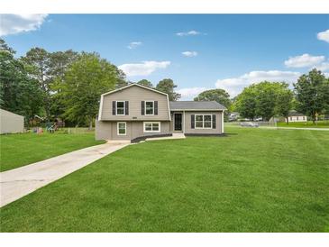 Charming home featuring a well-maintained lawn, complemented by fresh exterior paint and dark shutters at 1915 North Rd, Snellville, GA 30078