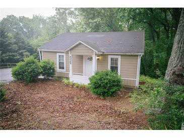 Charming cottage-style home featuring a cozy front porch and a well-maintained, tree-lined landscape at 329 Kelly Mill Rd, Cumming, GA 30040