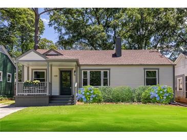 Charming single-story home featuring a cozy front porch, well-manicured lawn, and lush landscaping at 139 Sisson Ne Ave, Atlanta, GA 30317