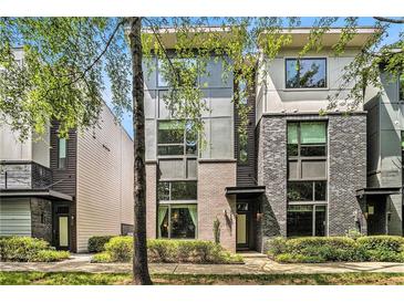 Modern townhouse with brick facade and large windows, surrounded by lush greenery at 710 Oakview Rd, Decatur, GA 30030