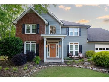 Charming two-story home featuring a well-maintained lawn, a combination brick and vinyl facade, and a welcoming front porch at 4130 Providnce Square, Alpharetta, GA 30009