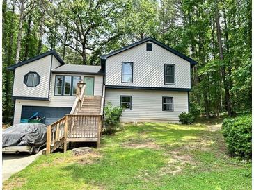 Charming two-story home featuring a front porch with wood accents and a serene wooded surrounding at 2816 Quinbery Dr, Snellville, GA 30039