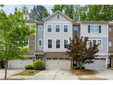 Charming townhome featuring a gray exterior with a brick facade and a one-car garage at 2817 White Oak Ln, Decatur, GA 30032