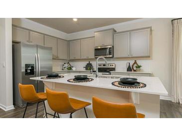 Modern kitchen featuring stainless steel appliances, gray cabinetry, and a quartz island with seating at 3050 Yellowhammer Dr, Marietta, GA 30064
