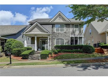 Charming two-story home with stone accents, landscaped front yard, and inviting covered porch at 595 Stonepark Ln, Suwanee, GA 30024