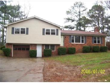 Charming two-story home featuring a brick facade, attached garage, and well-maintained landscaping at 401 Mount Tabor Church Rd, Dallas, GA 30157