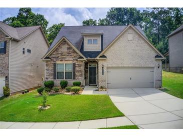 Charming home featuring stone and brick exterior with a well-manicured lawn and attached two-car garage at 555 Lance View Ln, Lawrenceville, GA 30045