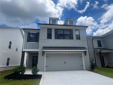 Charming two-story home featuring a finished garage and neutral gray painted brick at 4524 Eastbrook Pl, Snellville, GA 30039