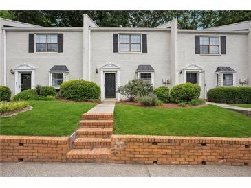 Charming townhouse with brick facade, well-maintained lawn, and black shutters on light colored brick at 1771 Defoor Nw Ave # D, Atlanta, GA 30318