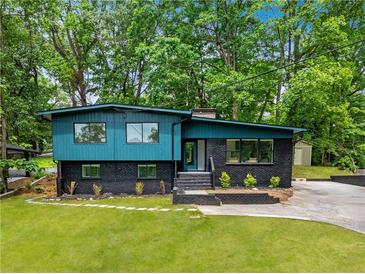 Stunning renovated home with an elegant blue and black exterior and well-manicured lawn at 2873 Bob White Sw Dr, Atlanta, GA 30311