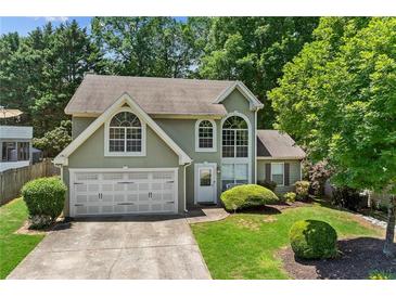 Charming home with a manicured lawn, two-car garage, and mature trees offering curb appeal at 850 Long Branch Cir, Sugar Hill, GA 30518