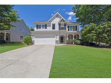 Charming two-story home with stone accents, well-manicured lawn, and an attached two-car garage at 955 Mill Creek Ave, Canton, GA 30115