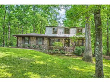 Charming two-story brick home nestled in a wooded setting with a beautifully landscaped front yard at 1580 Smyrna Sw Rd, Conyers, GA 30094