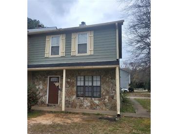 Two-story townhouse featuring stone accents, green siding, shuttered windows, and a welcoming front door at 3500 Ten Oaks Ct, Powder Springs, GA 30127